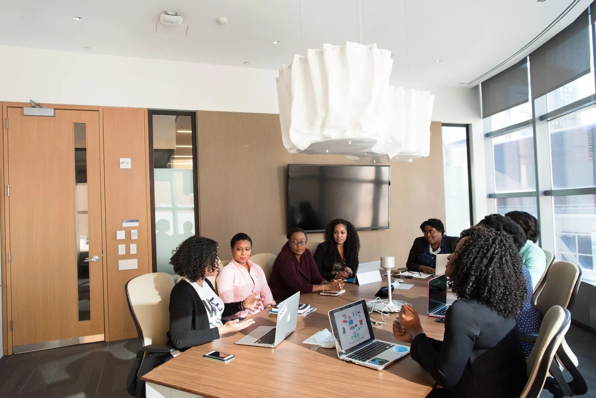 A team around a boardroom table with laptops open